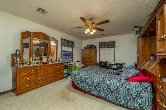 carpeted bedroom with ceiling fan and a textured ceiling