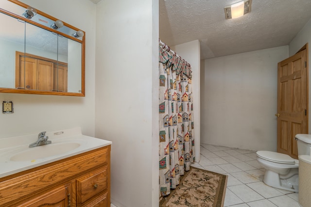 bathroom featuring curtained shower, vanity, a textured ceiling, toilet, and tile patterned floors