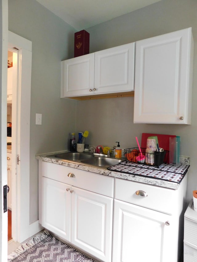 kitchen featuring white cabinetry and sink