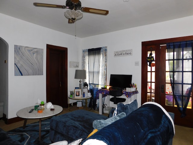 carpeted living room with ceiling fan