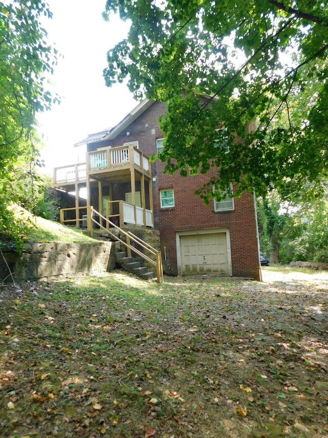 back of property featuring a garage and a deck