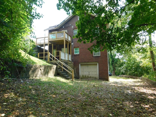 back of property featuring a garage and a wooden deck