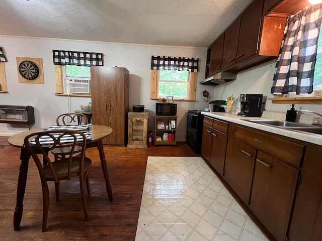 kitchen featuring sink, a textured ceiling, dark brown cabinets, cooling unit, and black appliances