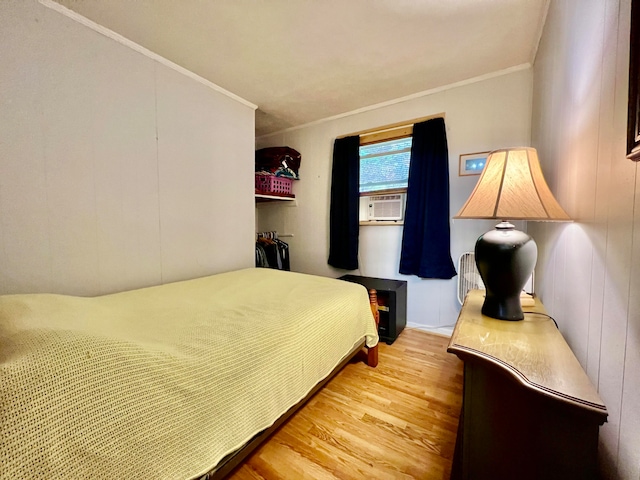 bedroom featuring crown molding and light hardwood / wood-style flooring