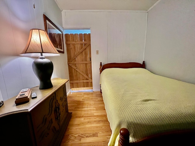 bedroom featuring a barn door and light hardwood / wood-style flooring