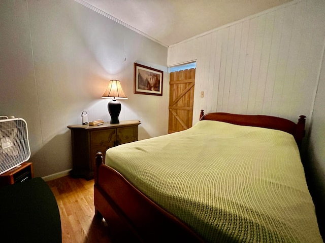 bedroom with wood-type flooring and crown molding