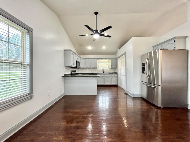 kitchen featuring stainless steel appliances, kitchen peninsula, dark hardwood / wood-style floors, and a healthy amount of sunlight