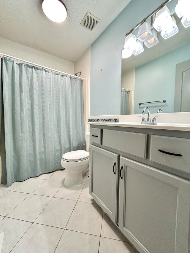 bathroom featuring a textured ceiling, tile patterned flooring, vanity, and toilet