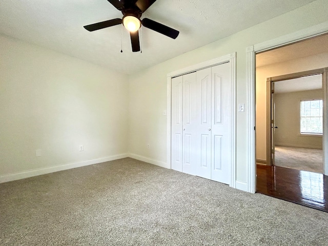 unfurnished bedroom featuring a closet, ceiling fan, carpet floors, and a textured ceiling