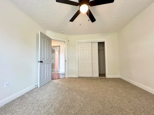 unfurnished bedroom with a closet, ceiling fan, carpet flooring, and a textured ceiling