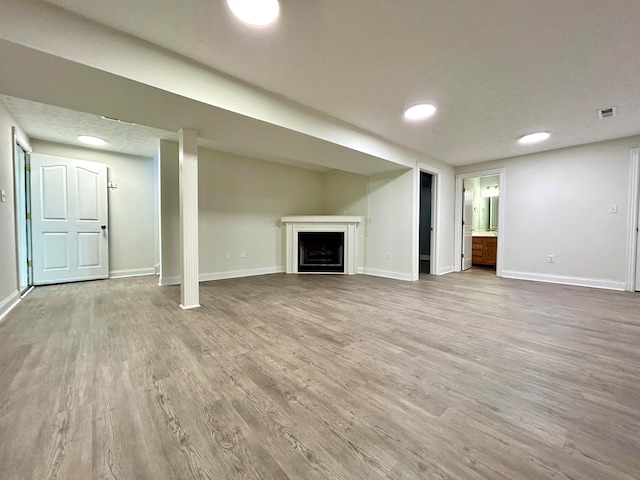 basement with wood-type flooring and a textured ceiling