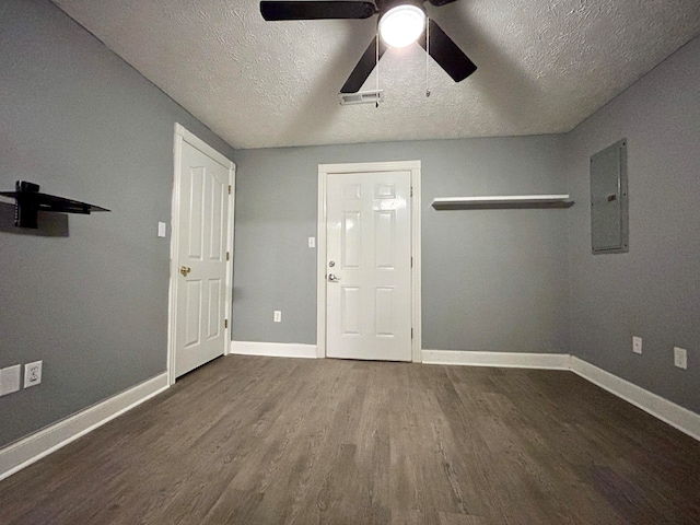 interior space featuring a textured ceiling, dark hardwood / wood-style floors, ceiling fan, and electric panel