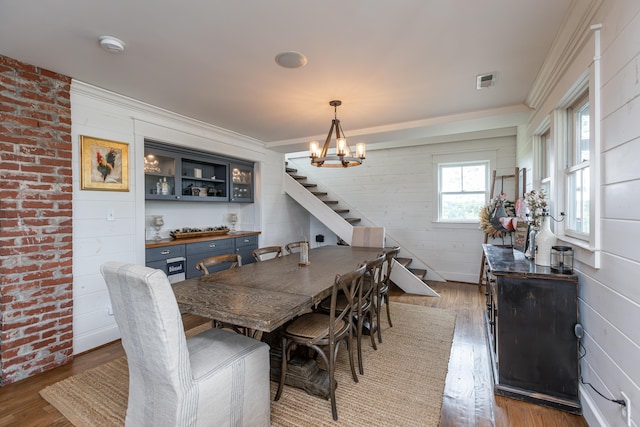 dining space with crown molding, dark hardwood / wood-style floors, and a chandelier