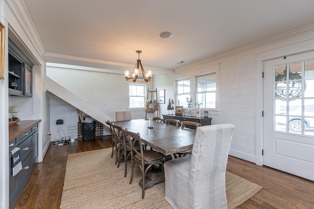 dining area with a wealth of natural light, a chandelier, crown molding, and dark hardwood / wood-style flooring