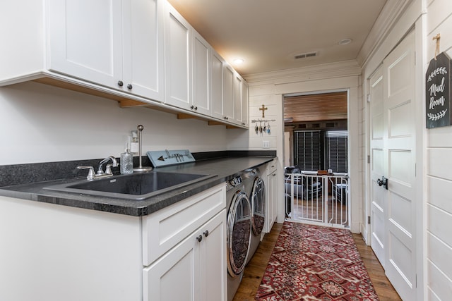 laundry area with dark hardwood / wood-style flooring, cabinets, washer and clothes dryer, and sink