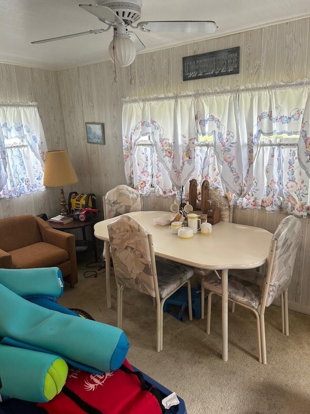 carpeted dining area with ceiling fan