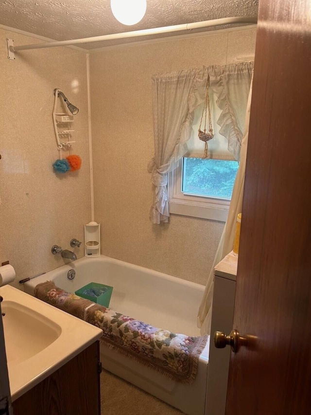 bathroom with washtub / shower combination, a textured ceiling, and vanity