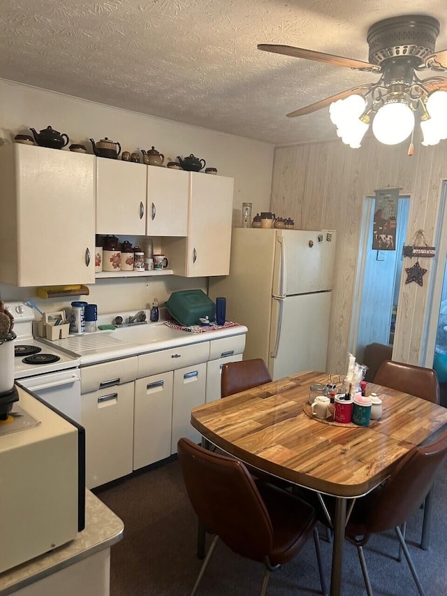 kitchen featuring ceiling fan, white cabinets, a textured ceiling, and white appliances