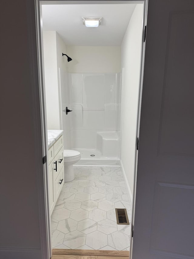 bathroom with toilet, vanity, and walk in shower