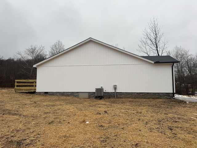 view of side of home featuring a lawn and central AC unit