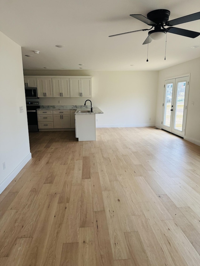 kitchen with range with electric stovetop, light hardwood / wood-style floors, french doors, and sink