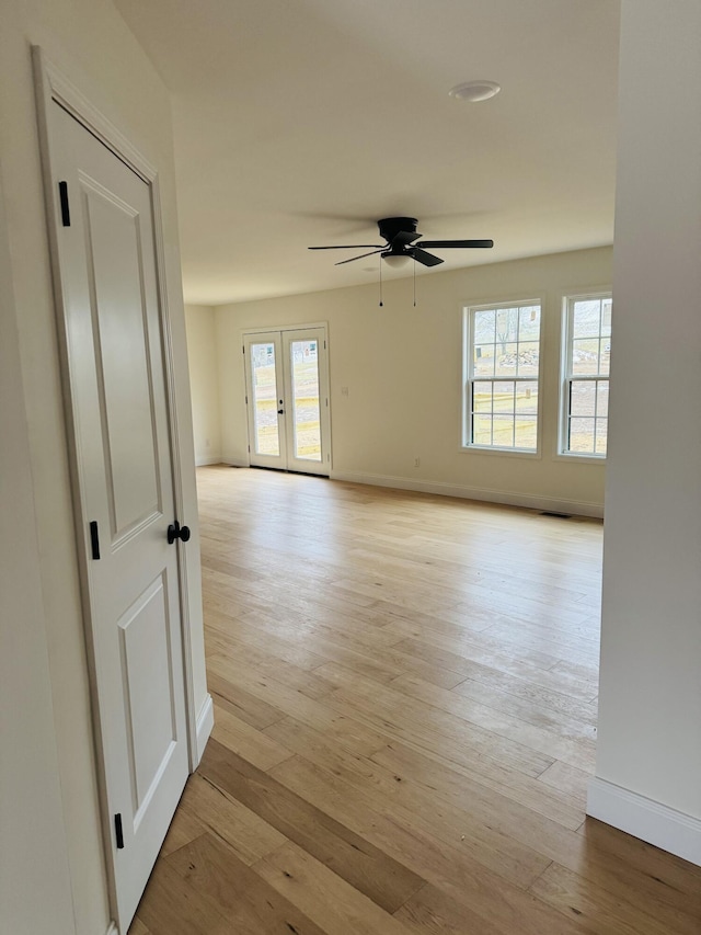 spare room featuring ceiling fan, a wealth of natural light, and light hardwood / wood-style floors