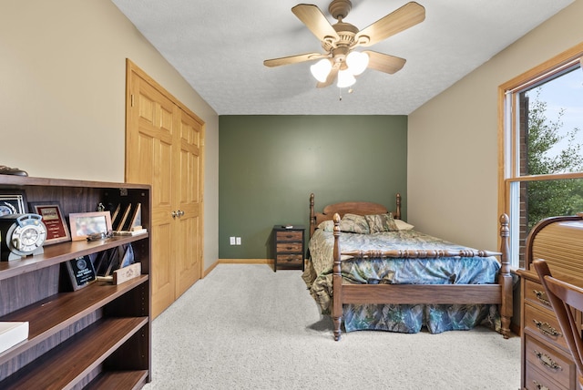 bedroom featuring a textured ceiling, carpet, and ceiling fan