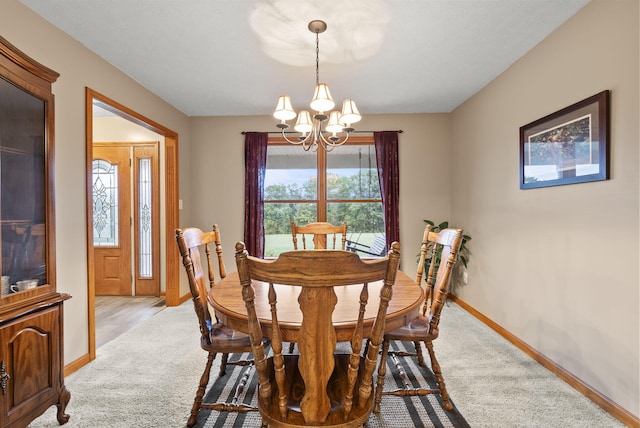 dining space featuring light carpet and an inviting chandelier