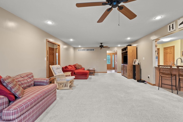 carpeted living room featuring ceiling fan