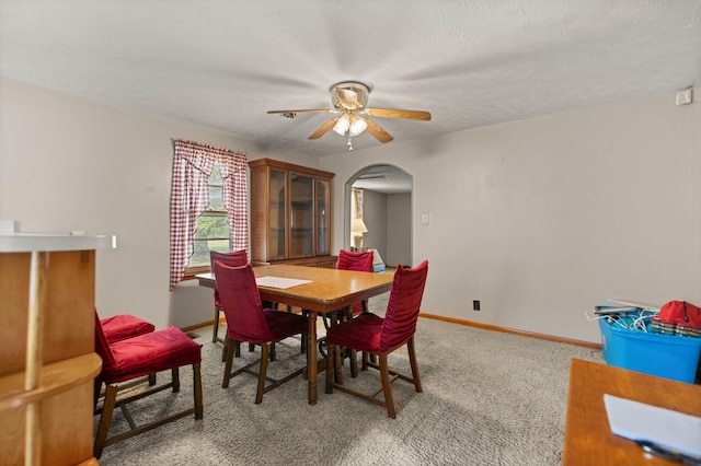 carpeted dining area featuring ceiling fan and a textured ceiling