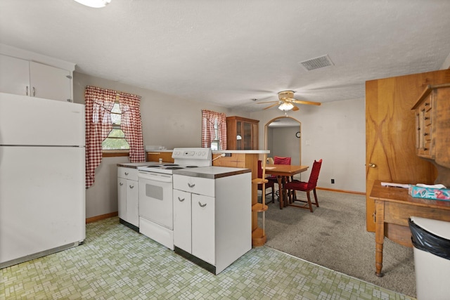 kitchen featuring white appliances, ceiling fan, kitchen peninsula, and white cabinets