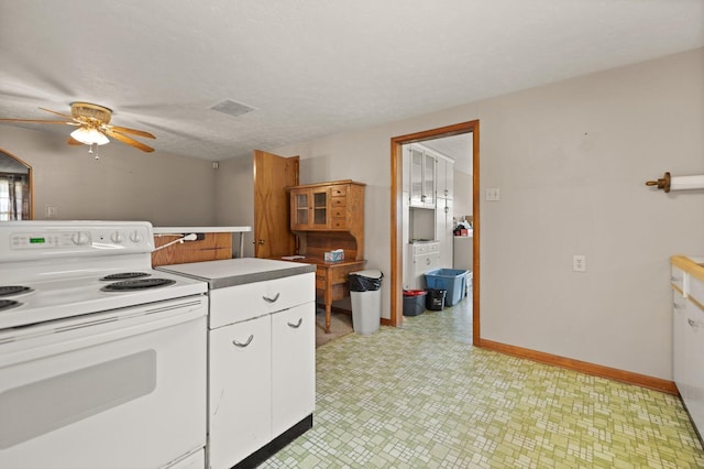 kitchen featuring ceiling fan, a textured ceiling, wooden walls, white cabinetry, and electric stove