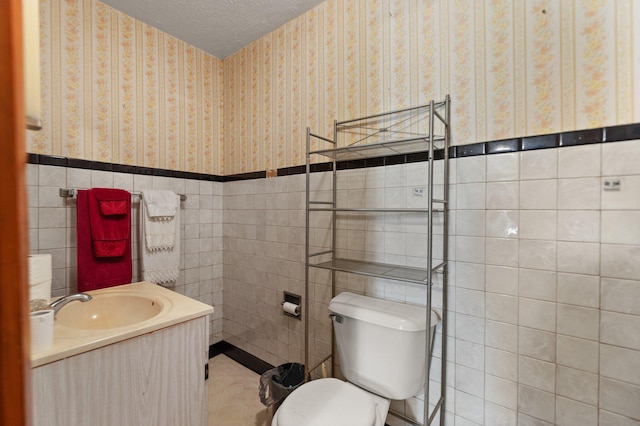 bathroom featuring tile walls, vanity, and toilet