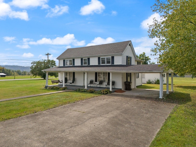 farmhouse inspired home featuring a front yard, a porch, and a carport