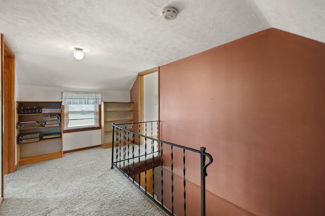 hall with light carpet, a textured ceiling, and lofted ceiling