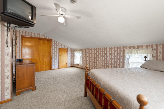 bedroom featuring multiple windows, carpet flooring, vaulted ceiling, and ceiling fan