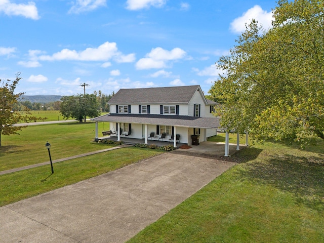 farmhouse inspired home with a front lawn, covered porch, and a carport