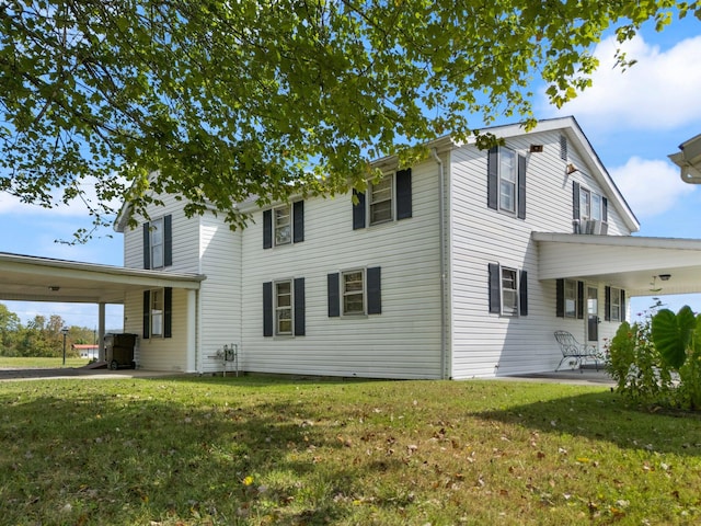 exterior space featuring a front lawn and a carport