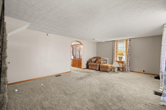 unfurnished room featuring a textured ceiling and carpet floors