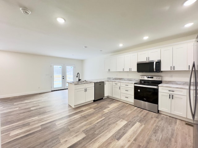 kitchen featuring white cabinets, kitchen peninsula, and appliances with stainless steel finishes