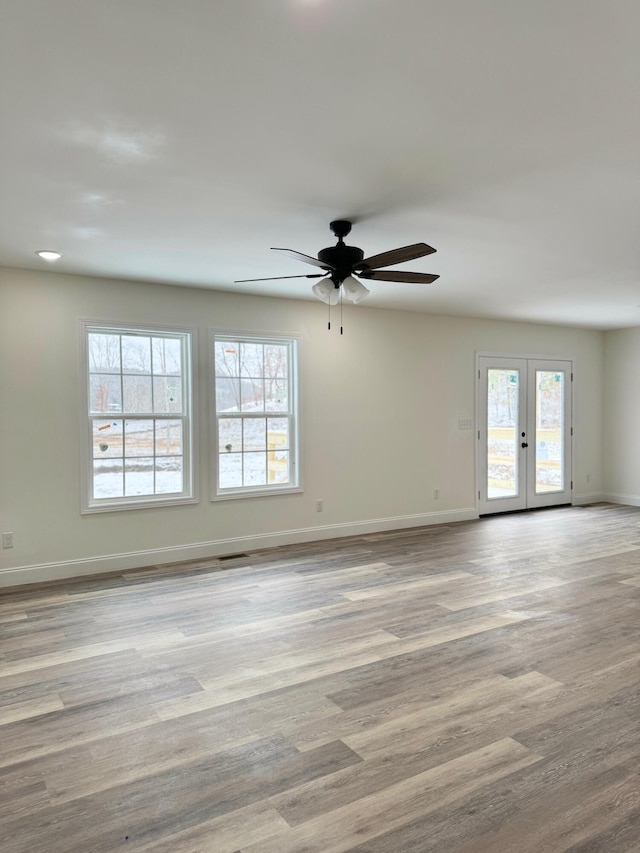 unfurnished room featuring ceiling fan, french doors, and light wood-type flooring