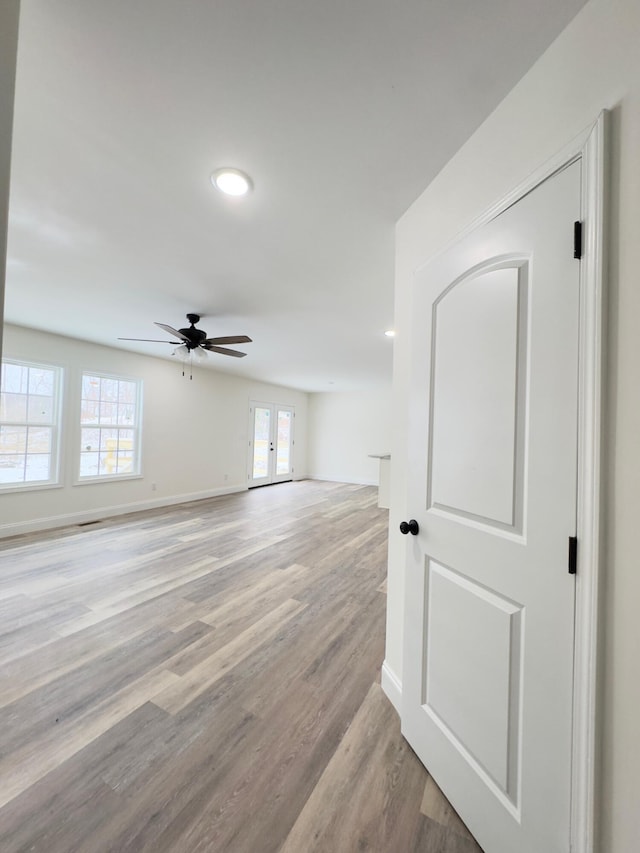 unfurnished room featuring ceiling fan, light wood-type flooring, and french doors