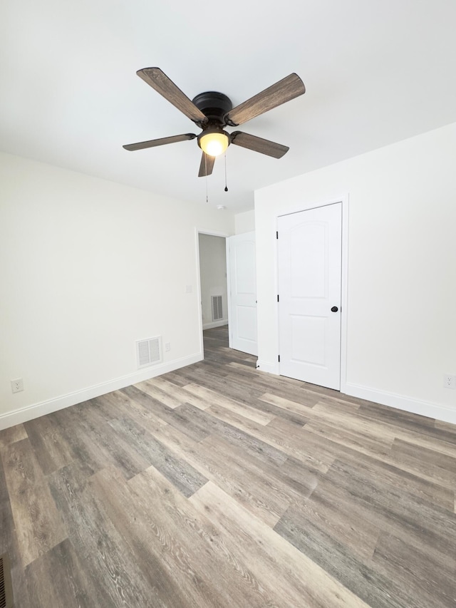 unfurnished room with ceiling fan and wood-type flooring