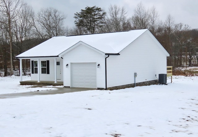 exterior space with covered porch, a garage, and central air condition unit