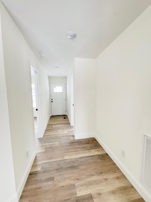 corridor with light hardwood / wood-style flooring