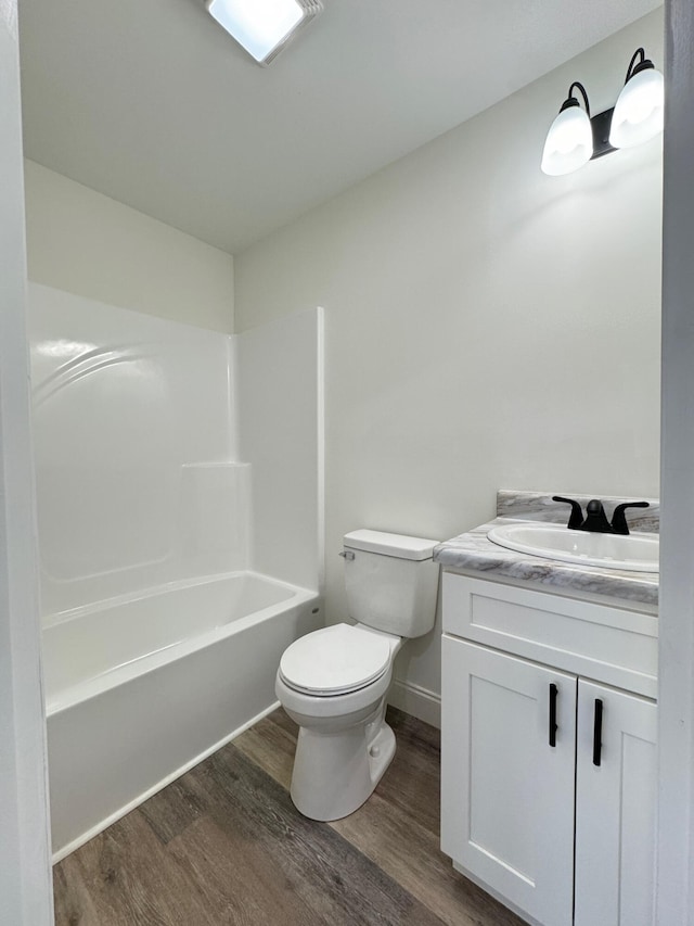 full bathroom featuring hardwood / wood-style flooring, vanity, shower / bathtub combination, and toilet