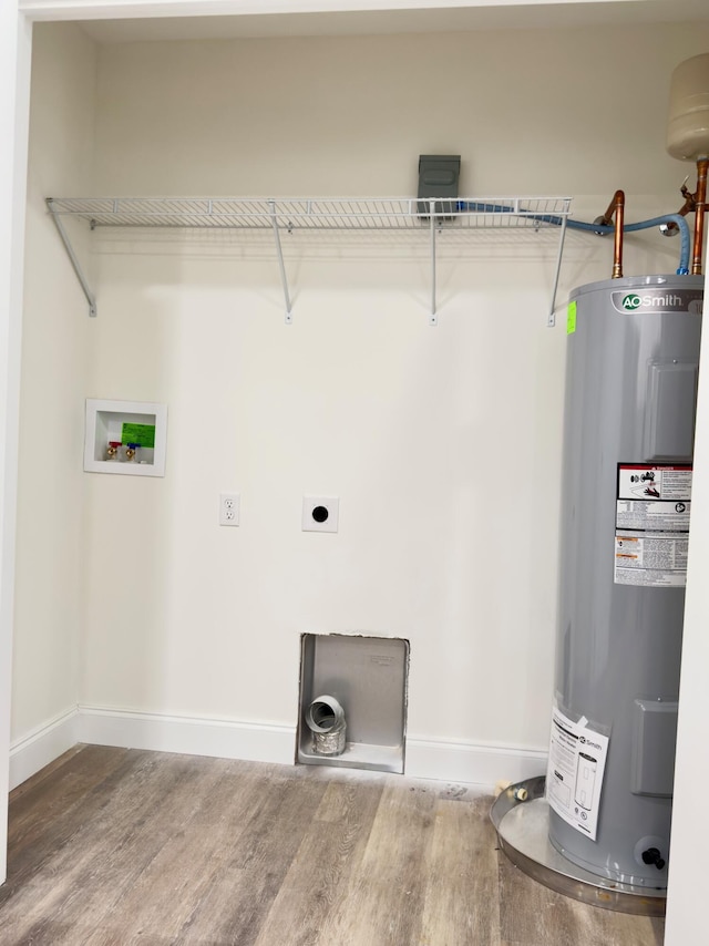 washroom featuring water heater, hookup for a washing machine, hardwood / wood-style floors, and hookup for an electric dryer