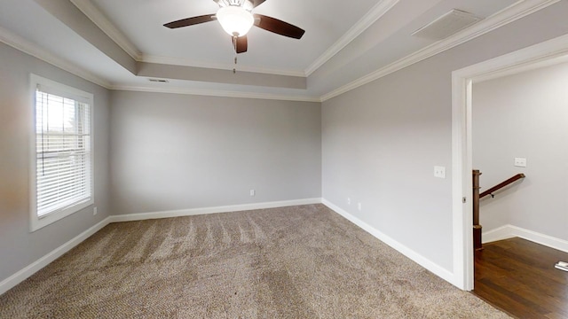 carpeted empty room with ceiling fan, a tray ceiling, and ornamental molding