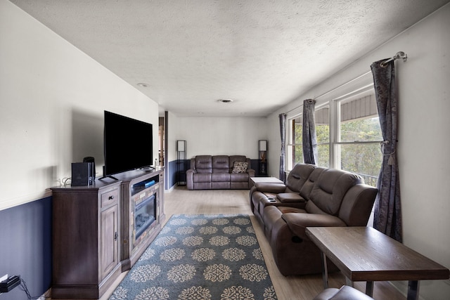 living room featuring light hardwood / wood-style floors and a textured ceiling