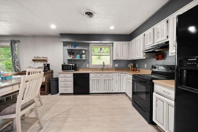 kitchen with black appliances, a textured ceiling, white cabinetry, and sink